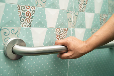 Cropped hand of woman holding metal