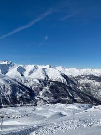 Scenic view of snowcapped mountains against blue sky