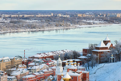 High angle view of townscape by sea during winter