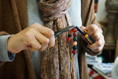 Midsection of woman repairing chain in store