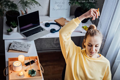 Woman on workplace with head massager scalp scratcher with fingers. self-massage with head