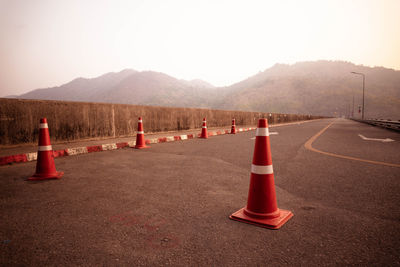 Road sign by mountains against sky