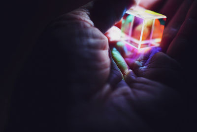 Close-up of hand holding illuminated candle