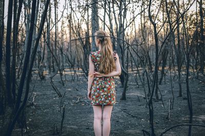 Portrait of young woman standing in forest