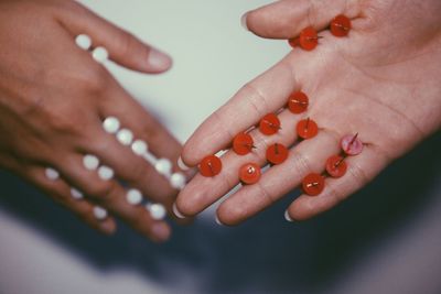 Close-up of cropped hands holding thumbtacks