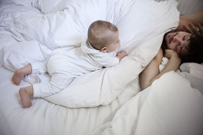 Father with baby son in bed, london, united kingdom