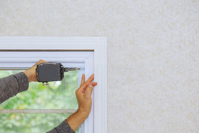 Close-up of man photographing against wall