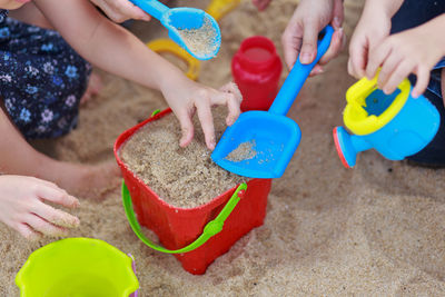 Close-up of hands holding sand on beach