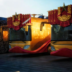 Carousel in amusement park against sky during sunset