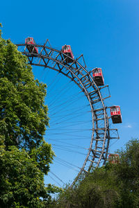 Low angle view of ferris wheel against clear blue sky