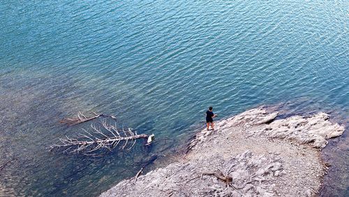 High angle view of man on rocks by sea