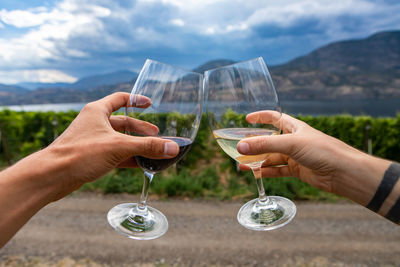 Cropped hands of couple holding wine glasses outdoors