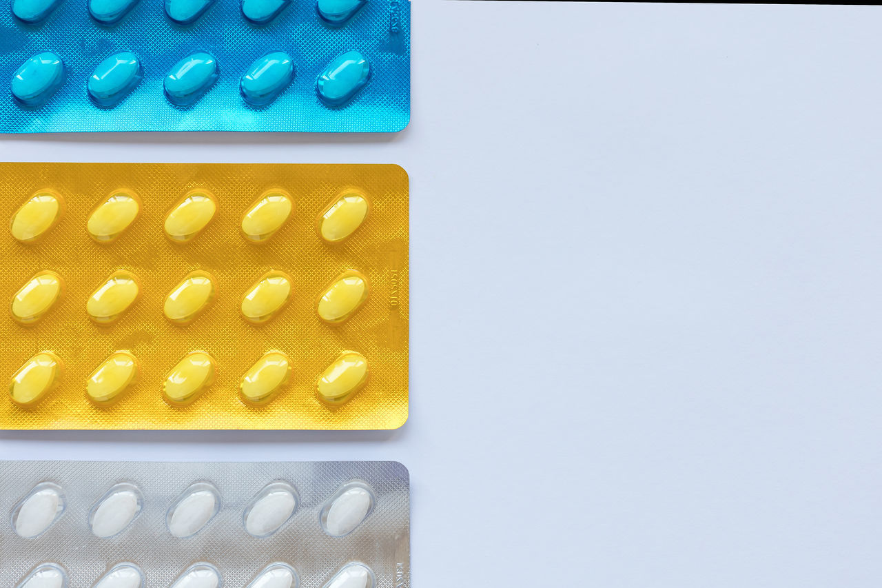pill, dose, healthcare and medicine, medicine, capsule, studio shot, no people, indoors, blue, drug, prescription medicine, yellow, blister pack, close-up, pharmaceutical drug, copy space, in a row, nutritional supplement