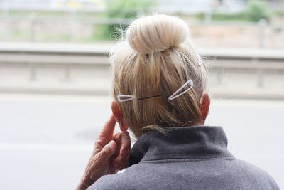 Rear view of senior woman at the street, head from behind, hair style