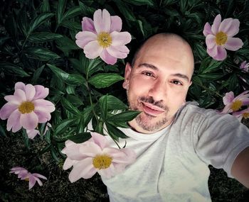 Portrait of woman with pink flowers against plants