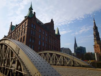 Low angle view of buildings against cloudy sky