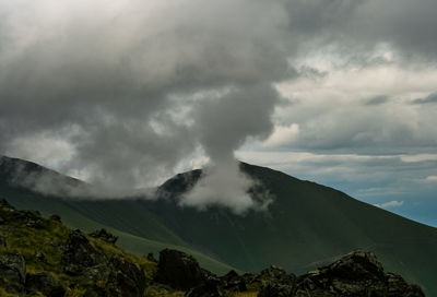 Scenic view of mountains against cloudy sky