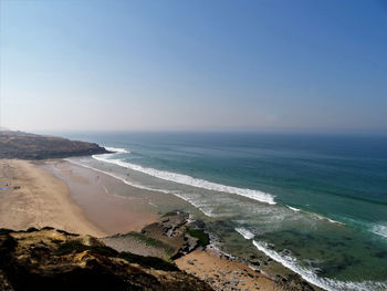 Scenic view of beach against clear blue sky