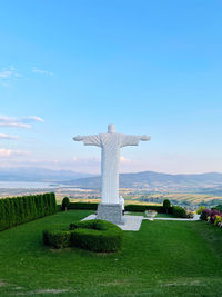 Statue on field against sky