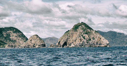 Rock formations by sea against sky