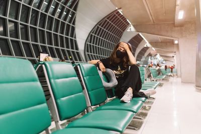 Frustrated female with mask touching head in airport