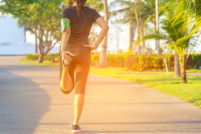 Rear view of woman walking on footpath