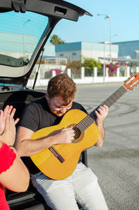 Rear view of man playing guitar