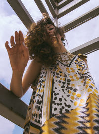 Low angle view of woman looking up against sky