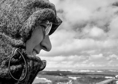 Close-up of man wearing hood against sky