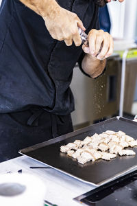 Midsection of man preparing food in kitchen