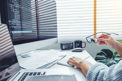 Midsection of man using mobile phone on table