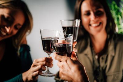 Close-up of happy friends toasting drinks