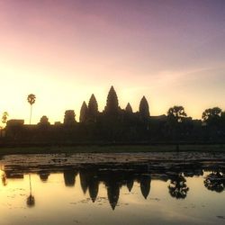 Reflection of built structures in water at sunset