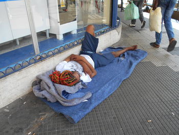 Low section of woman sitting on footpath