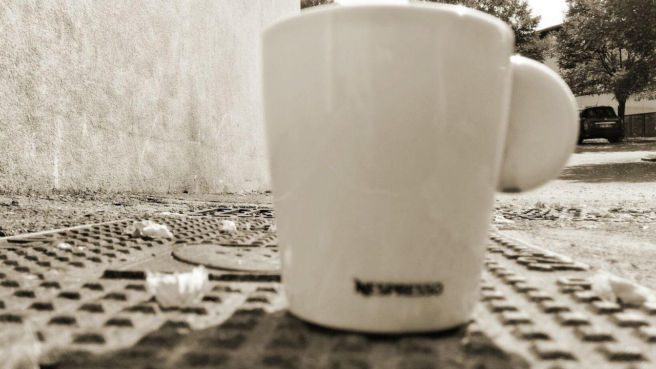 no people, close-up, selective focus, day, cup, nature, mug, coffee cup, outdoors, still life, table, metal, drink, container, disposable cup, city, pattern, architecture, disposable, sunlight, surface level, crockery