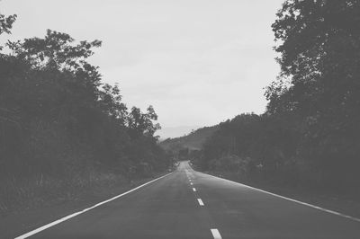 Road amidst trees against sky