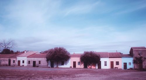 Houses and trees in city against sky