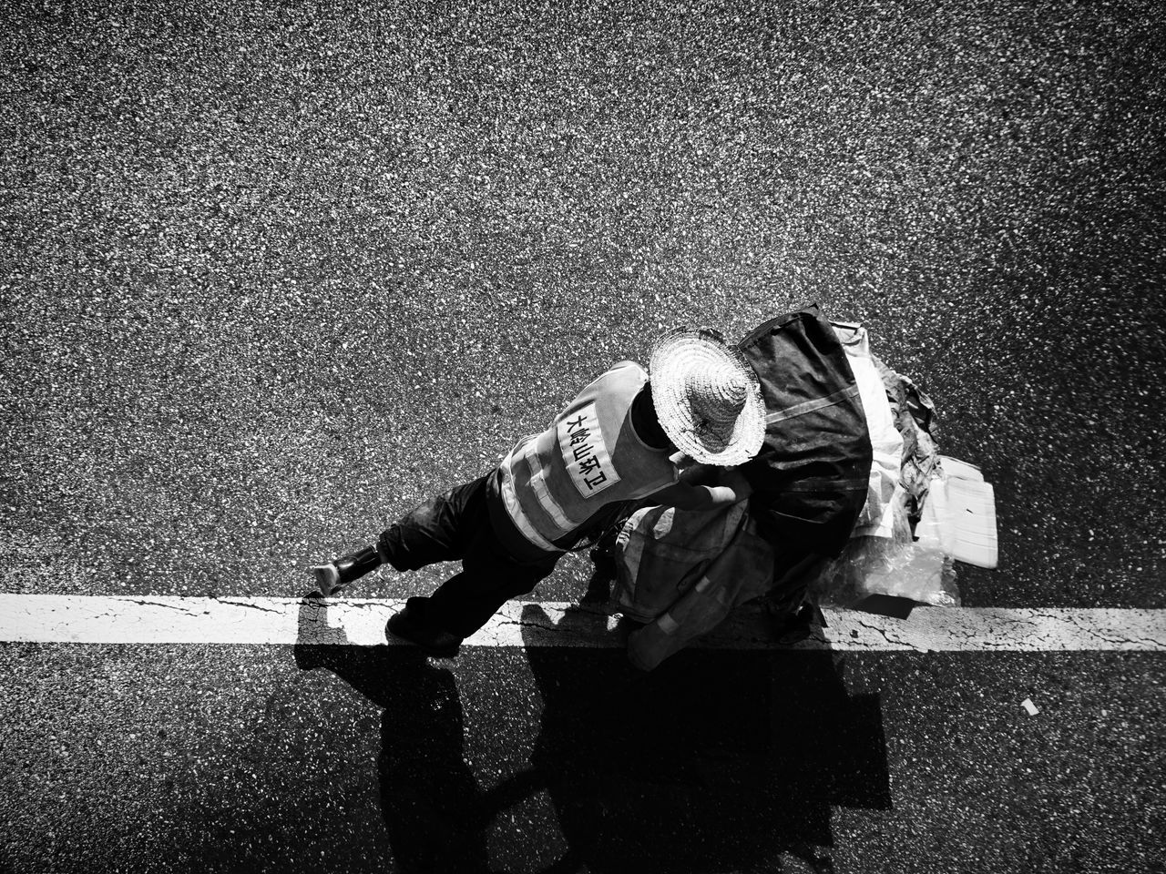 real people, road, high angle view, men, one person, day, full length, city, sunlight, nature, street, occupation, shadow, transportation, casual clothing, clothing, outdoors, sign, standing, uniform