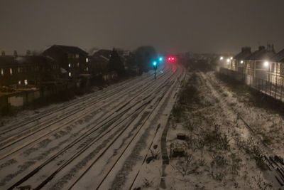 Railroad tracks in city at night during winter