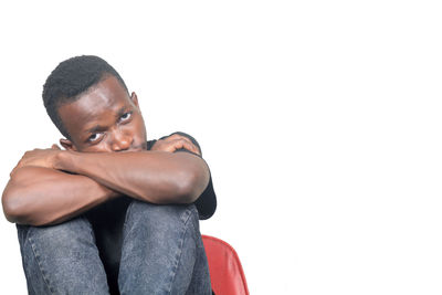 Portrait of young man looking away against white background