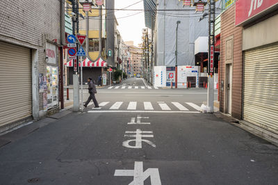 Road sign on street amidst buildings in city