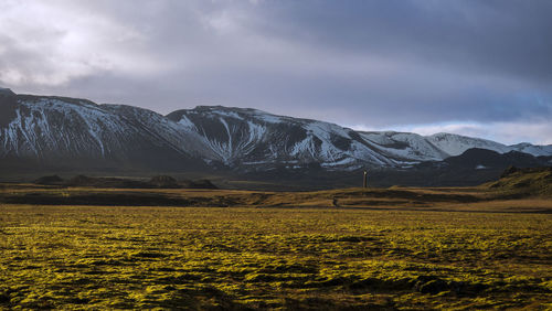 Scenic view of field and mountains against sky