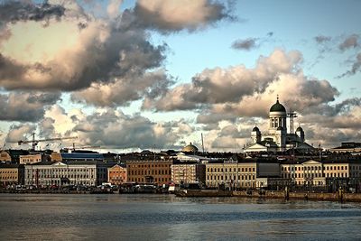 Buildings in city against cloudy sky