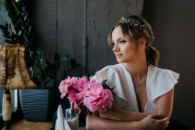 Portrait of woman with pink flower