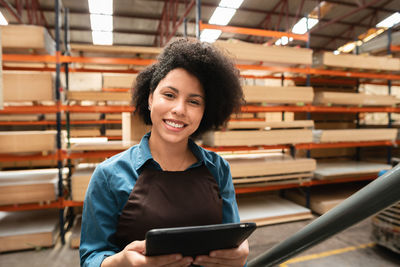 Portrait of young woman using mobile phone in library