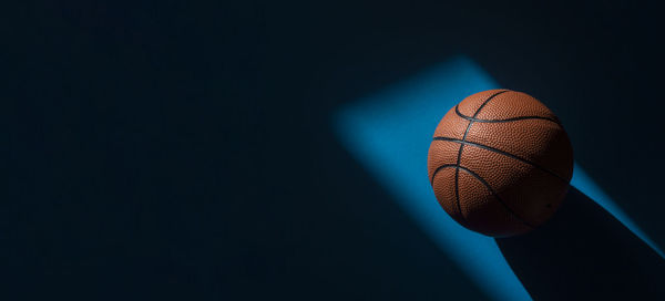 Close-up of basketball hoop against dark background