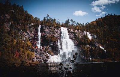 Scenic view of waterfall against sky