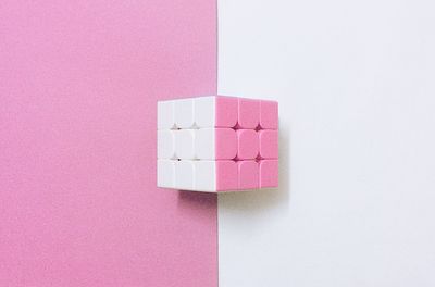 Directly above shot of dice over white and pink background