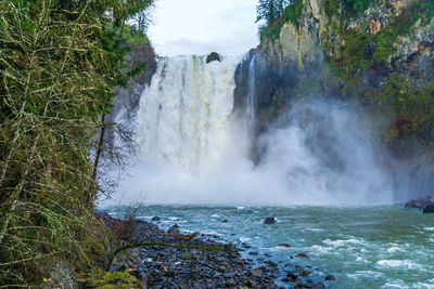 Water explodes at the bottom of snoqualmie falls in washington state.