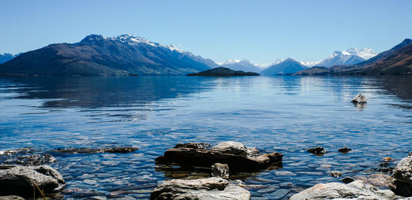 Scenic view of sea and mountains against clear sky